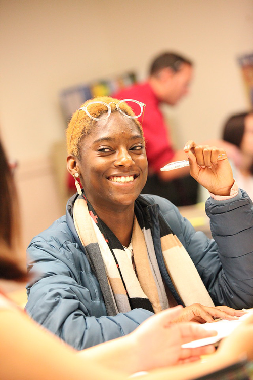 photo of smiling student sitting at desk
