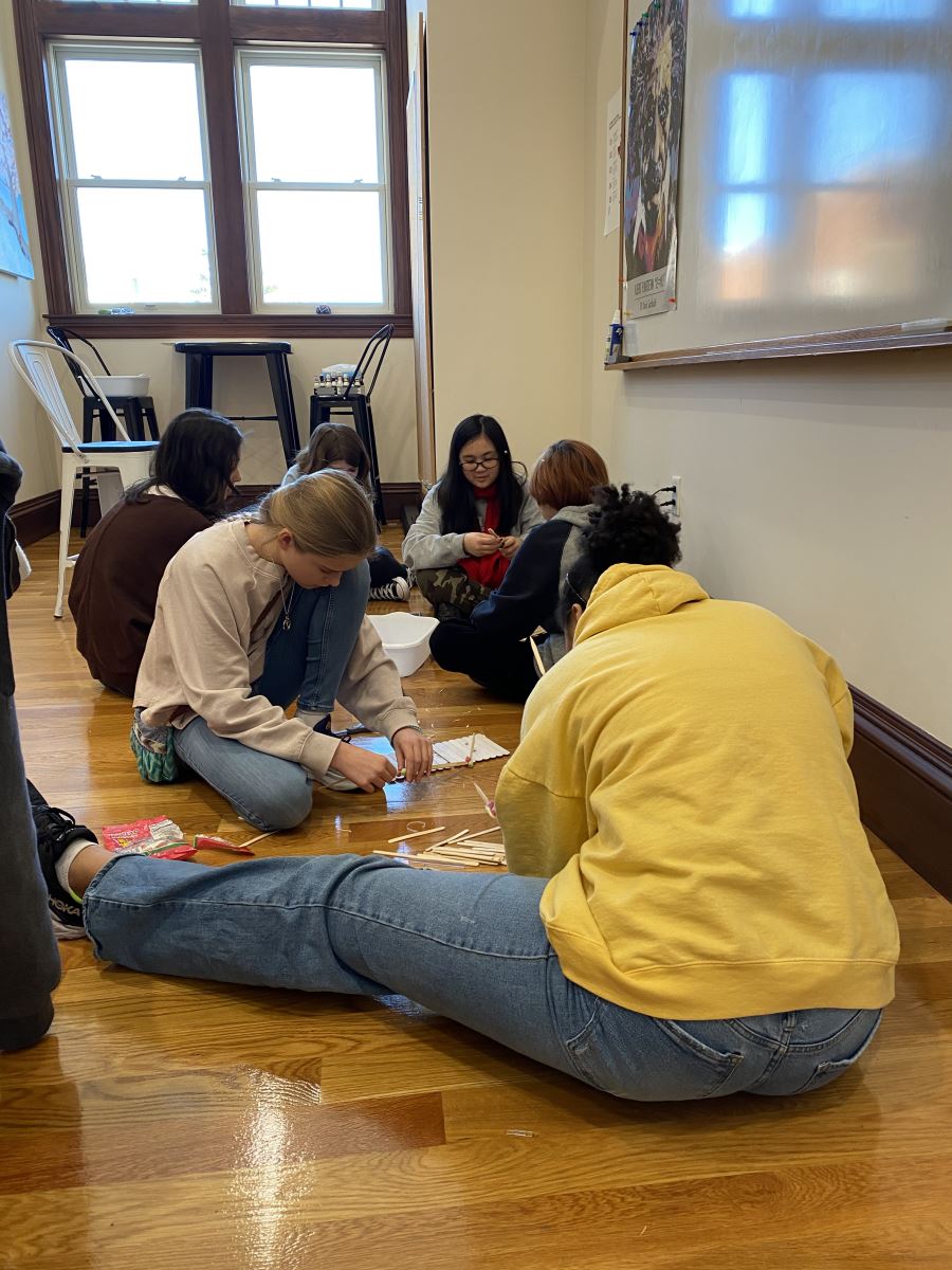 Woodward Middle School Students work together to construct the strongest possible popsicle stick bridge