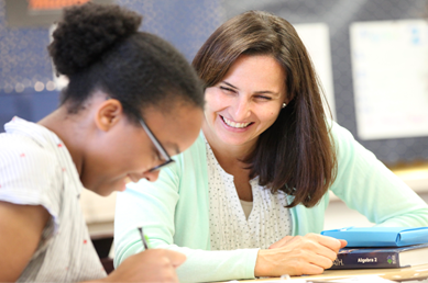 Teacher Assisting Student with Paper