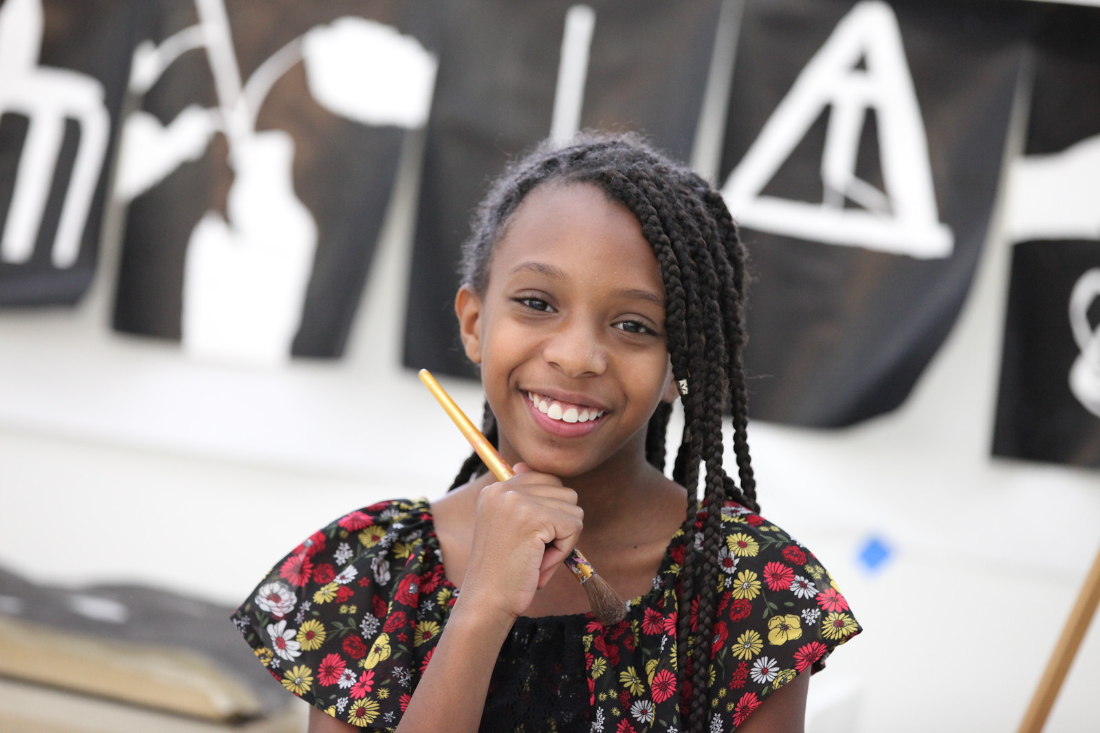 student posing with paintbrush