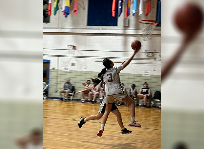 Woodward Basketball Player working to make a goal