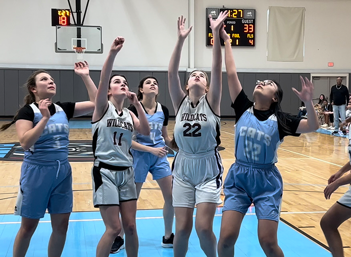 Woodward basketball player makes a shot while other players watch the ball