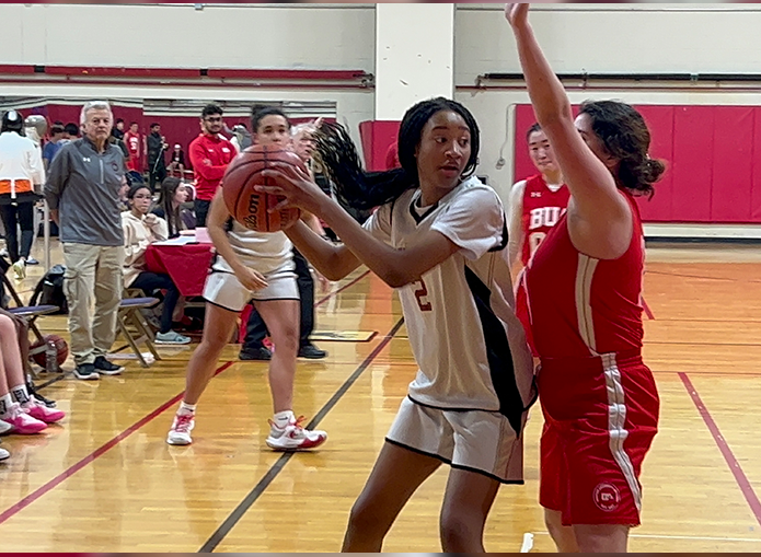 Woodward basketball player looking to pass as opposing player blocks