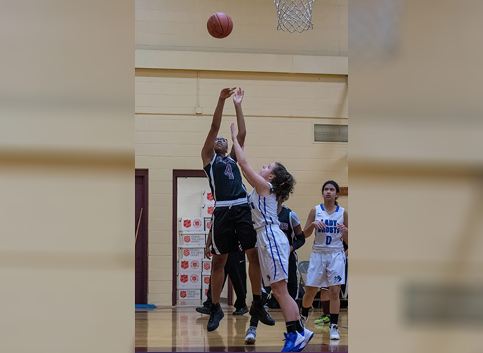 Woodward basketball player makes a shot while her opponent attempts to block