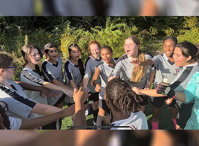 Woodward soccer players unite hands in huddle