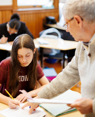 Woodward Teacher assisting Woodward Student with other Woodward Students in the background